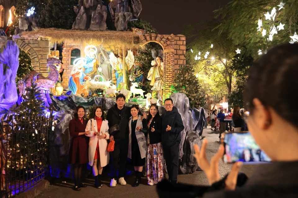 De nombreuses personnes viennent s'amuser et prendre des photos souvenirs dans le quartier de la cathédrale pendant Noël 2024. Photo : Hoang Hieu - VNA