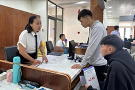 Le personnel du Centre de services administratifs publics du quartier de Tam Ky, dans la ville de Dà Nang, guide les gens dans les procédures administratives. Photo : VNA