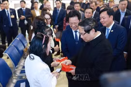 Le Premier ministre Pham Minh Chinh remet des enveloppes rouges symboliques du Têt aux voyageurs et au personnel ferroviaire, à la Gare de Hanoi, le lundi 27 janvier. Photo : VNA