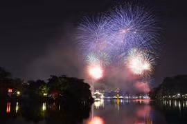 Des feux d'artifice illuminent le ciel au-dessus du lac Hoan Kiem pour célébrer l'Année du Serpent 2025. Photo: VNA