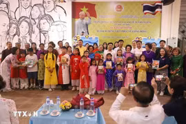 Les délégués posent avec les enfants lors de la cérémonie d’inauguration de la bibliothèque de livres en vietnamien à Udon Thani, en Thaïlande. Photo : VNA