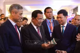 Le président du Sénat du Cambodge, Samdech Techo Hun Sen, visite les stands présentant les entreprises vietnamiennes implantées au Cambodge lors de la cérémonie. Photo : VNA