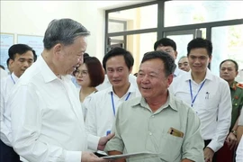 Le secrétaire général du Parti, Tô Lâm (à gauche), s’entretient avec des habitants au Centre des services administratifs publics de la commune de Phuc Thinh. Photo : VNA