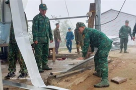Des soldats aident des habitants de la commune de Pa Ủ (province de Lai Châu) à stabiliser leurs conditions de vie après une tempête de grêle et de forts vents survenus vers 18 heures le 17 mars. Photo: VNA