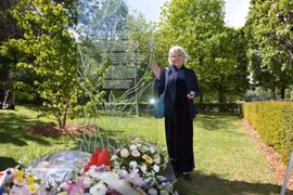 Mme Trân Tô Nga pose à côté de la plaque commémorative dédiée aux victimes de l’agent orange/dioxine au parc Choisy, dans le 13e arrondissement de Paris. Photo : VNA