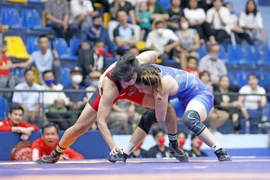 Nguyên Thi My Hanh (à droite) affronte l'Indonésienne Kharisma Tantri Herlina en finale de la catégorie des 62 kg femmes aux 31es Jeux d'Asie du Sud-Est. Photo: VNA