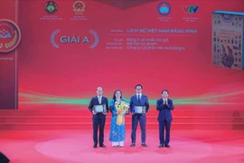 Trinh Van Quyêt, secrétaire du Comité central du Parti et chef de sa Commission de la sensibilisation, de l’éducation et de la mobilisation des masses, remet les prix A aux lauréats. Photo: VNA