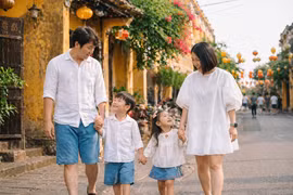 Une famille de touristes balade dans les ruelles étroites de la charmante cité de Hôi An. Photo : cafef.vn