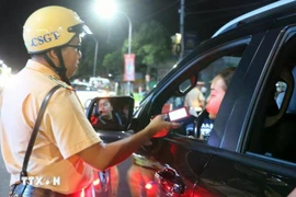 La police de la circulation de la ville de Long Xuyên contrôle au hasard le taux d'alcoolémie des usagers de la route. Photo: VNA