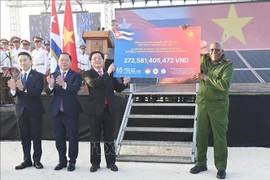 Le vice-Premier ministre Hô Quôc Dung remet symboliquement la deuxième tranche du programme de collecte de fonds « 65 ans d'amitié Vietnam-Cuba » organisé par la Croix-Rouge du Vietnam au vice-président cubain Salvador Valdés Mesa. Photo : VNA