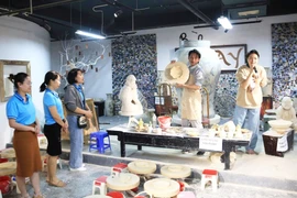 Des touristes dans le village de poterie de Bat Tràng. Photo: HNM