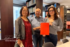 La chercheuse culturelle Trân Thu Dung (à gauche), Yonnel Ghernaouti, membre du conseil d'administration de l'Institut maçonnique de France, et Emma Lallemand, bibliothécaire au GODF, posent avec des documents d'archives sur Nguyên Ai Quôc. Photo : VNA