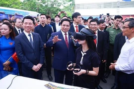 Le Premier ministre Pham Minh Chinh avec des étudiants participant au lancement officiel du mouvement national intitulé « La nation entière s'inspire de l'innovation et de la transformation numérique » à Hanoï. Photo: VNA