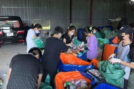 Des bénévoles du groupe Tagom, dans le quartier résidentiel de Thanh Xuân Bac, à Hanoi, trient les matières recyclables comme des bouteilles et des sacs en plastique des déchets ménagers. Photo : Tagom