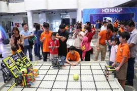 Des élèves s’essayent au contrôle d’un robot attrape-ballons lors d’un atelier sur l’application de l’IA à l’apprentissage à l’école primaire et secondaire FPT de la ville de Dà Nang. Photo : VNA