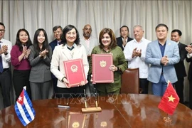 La vice-ministre vietnamienne de l’Industrie et du Commerce, Phan Thi Thang, et la vice-ministre cubaine du Commerce international et des Investissements étrangers, Deborah Rivas Saavedra, signent le procès-verbal de la réunion. Photo : VNA