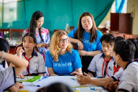 Des membres du personnel de l’UNICEF participent à une discussion avec des enfants vietnamiens. Le partenariat de 50 ans entre le gouvernement vietnamien et l’UNICEF a connu une transformation significative. Photo : UNICEF Vietnam