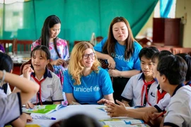 Des membres du personnel de l’UNICEF participent à une discussion avec des enfants vietnamiens. Le partenariat de 50 ans entre le gouvernement vietnamien et l’UNICEF a connu une transformation significative. Photo : UNICEF Vietnam