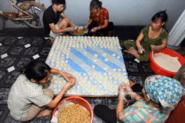 Production de gâteaux de riz gluant ronds. Photo: VNA