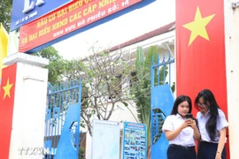 Des électrices âgées de 18 ans du lycée Ly Tu Trong s'informent sur les élections. Photo: VNA