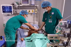 Des médecins examinent l'état de santé d'un des patients intoxiqués au botulisme sous surveillance médicale à l'Hôpital pour femmes et enfants de Dà Nang. Photo : VNA