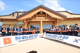 Les délégués sud-coréens et vietnamiens signent des tuiles à contruire le toit de la Maison communautaire de Bonghwa. Photo : VNA