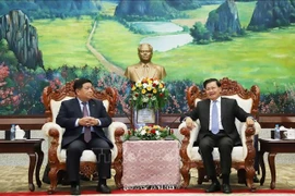 Le secrétaire général et président lao Thongloun Sisoulith et le vice-Premier ministre vietnamien Nguyên Chi Dung (à gauche), lors de leur rencontre à Vientiane, le 9 juillet Photo : VNA