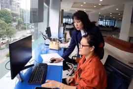Deux agentes du Centre des services administratifs publics de Hanoi effectuent les tâches sur l'ordinateur. Photo : VNA