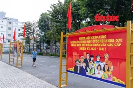 Un homme faisant de la gymnastique passe près ds banderoles et des slogans sur les élections législatives affichés dans les zones résidentielles et les espaces publics du quartier de Thông Tây Hôi, à Hô Chi Minh-Ville. Photo : Journal "Tin tuc và Dân tôc"