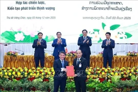 Lors de la signature et de l'échange d'accords de coopération, à Vientiane, le 3 décembre. Photo : VNA