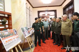 Le général Phan Van Giang présente aux dirigeants militaires étrangers une exposition de photos présentant les activités commémorant le 80e anniversaire de la Révolution d’Août et de la Fête nationale, le 2 septembre. Photo : qdnd