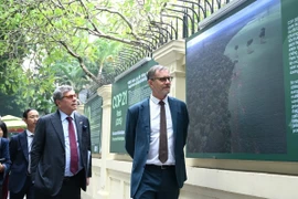 L'ambassadeur de France au Vietnam, Olivier Brochet et l'ambassadeur du Brésil au Vietnam, Marco Farani à l’exposition photographique commémorant le 10ᵉ anniversaire de l’Accord de Paris et illustrant le soutien de la France au Vietnam. Photos : nongnghiepmoitruong.vn