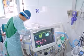 Un agent de santé pratique des soins à un patient atteint de Covid-19. Photo : laodong.vn