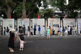 Une file de visiteurs faisant la queue pour découvrir l’exposition photographique « Éclat du nom de l’Oncle » et recevoir le supplément spécial du Journal Nhân Dân, à l’occasion du 135e anniversaire de la naissance du président Hô Chi Minh. Photo : NDEL