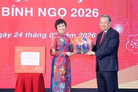 La directrice générale de la VNA, Vu Viêt Trang, remet au secrétaire général Tô Lâm un livre de photos réalisé par les journalistes du Département de rédaction des photos de presse. Photo: VNA