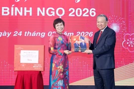 La directrice générale de la VNA, Vu Viêt Trang, remet au secrétaire général Tô Lâm un livre de photos réalisé par les journalistes du Département de rédaction des photos de presse. Photo: VNA