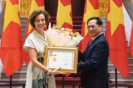 Le vice-Premier ministre et ministre des Affaires étrangères Bui Thanh Son remet à la directrice générale de l’UNESCO, Audrey Azoulay, l’insigne « Pour la cause de la diplomatie vietnamienne». Photo : VNA
