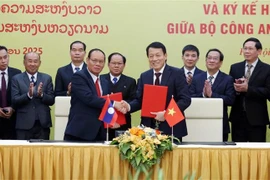 Le ministre vietnamien de la Sécurité publique, Luong Tam Quang (à droite, premier plan), et le vice-Premier ministre lao et ministre de la Sécurité publique, Vilay Lakhamphong se serrent la main, à Hanoi, le 12 janvier. Photo: VNA