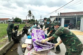 Des soldats nettoient les routes dans la la commune de Hoa Thinh, dans la province de Dak Lak. Photo : VNA