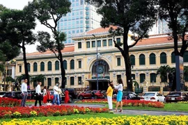 Des touristes devant la Poste centrale de Hô Chi Minh-Ville. Photo: VNA