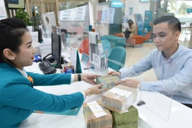Un client dépose son épargne à une banque à Hanoi. Photo: vneconomy.vn