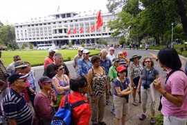 Des touristes étrangers écoutent une présentation sur l'histoire du Palais de l'Indépendance. Photo: doanhnhansaigon.vn