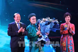 Le vice-ministre de la Culture, des Sports et du Tourisme, Ta Quang Dông, et la directrice générale de la VNA, Vu Viêt Trang, remettent le Prix «Artiste inspirant» à l'artiste Chu Bao Quê. Photo: VNA
