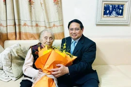 Le Premier ministre Pham Minh Chinh rend visite à l'ancienne vice-présidente Nguyên Thi Binh, le 8 mars. Photo : VNA