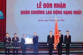 Le secrétaire général du Parti, Tô Lâm (au centre), décerne l’Ordre du Travail de première classe au journal Nhân Dân, à Hanoi, le 11 mars. Photo : VNA