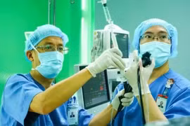 Le professeur associé Le Thuong Vu (à gauche) effectue une bronchoscopie avec échographie endobronchique (EBUS) à visée de biopsie. Photos: NDEL