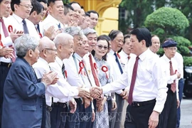 Le président Luong Cuong serre la main des journalistes chevronnés, à Hanoi, le 20 juin. Photo : VNA