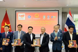 Des ressortissants vietnamiens reçoivent une copie du livre bilingue "L'Oncle Hô en Thaïland". Photo: VNA