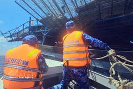 Les officiers et les membres d'équipage du navire 314 portent assistance au bateau de pêche en détresse QNa 91117 TS. Photo: VNA