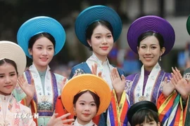Des femmes et des enfants dans leur ao dài, la tunique longue et gracieuse que chaque vietnamienne porte à tout âge. Photo : VNA